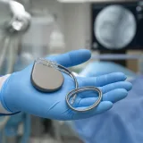 Eldivenli avuçta tutulan ICD (şoklu kalp pili) cihazı ve kablosu (temsili görsel)
