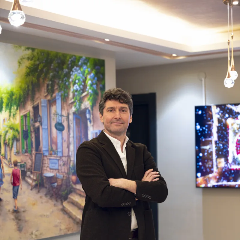 Prof. Dr. Umuttan Doğan muayenehanesinin bekleme salonunda, kolları kavuşturulmuş hâlde