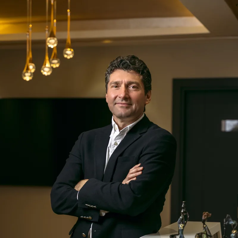 Prof. Dr. Umuttan Doğan muayenehanesinin karşılama bankosuna yaslanmış hâlde